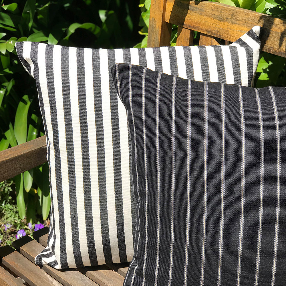 Jenna cushion. Black and white stripes made with 100% organic cotton and natural dyes. Featuring Maggie cushion. Designed by Woven. Handmade in Guatemala.