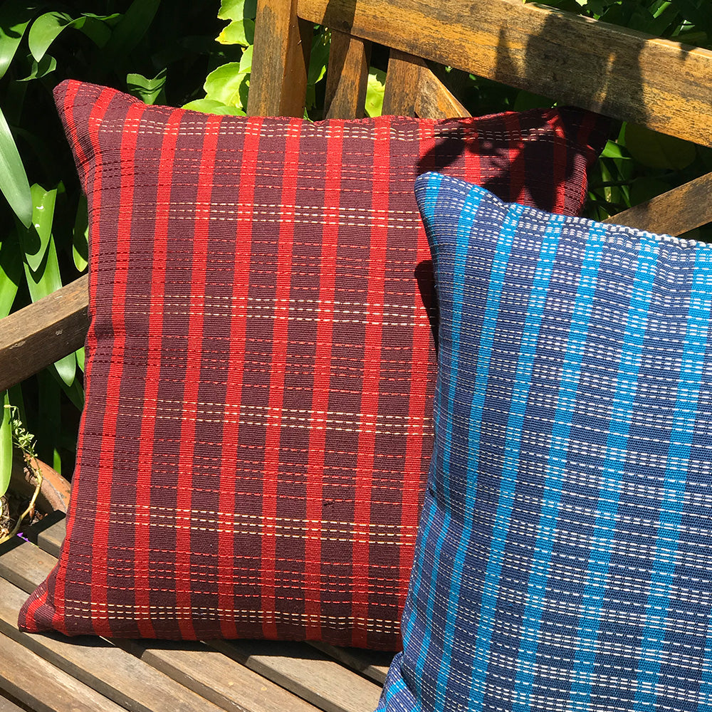 GIA cushion with red and brown horizontal stripes, and red and gold vertical stripes. Designed by Woven. Handmade in Guatemala.
