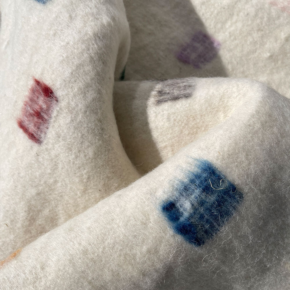 Cozy white blanket with multi coloured spots made from 100% Sheep wool and all natural dyes. Designed by Woven. Handmade in Guatemala.