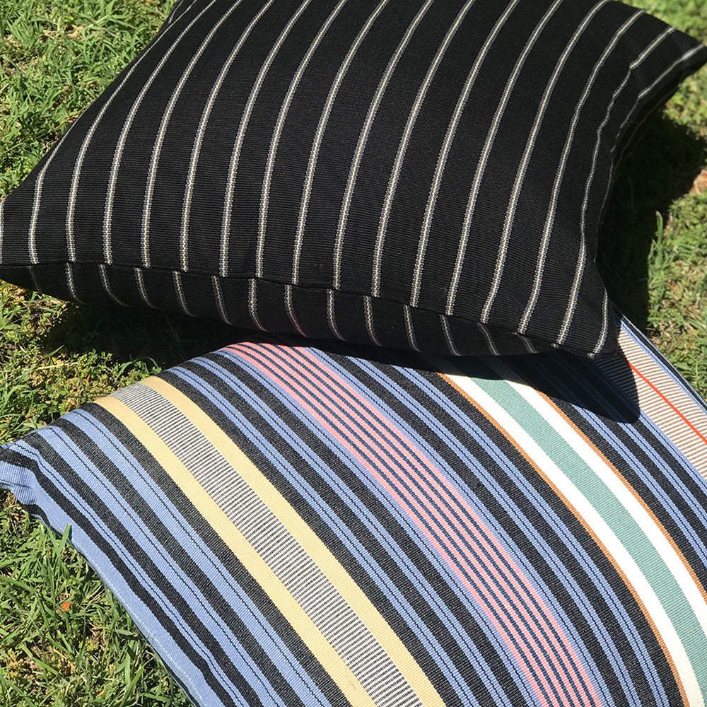 Filip cushion with multi coloured stripes, made with 100% organic cotton. Featuring Jenna cushion with black and white stripes. Designed by Woven. Handmade in Guatemala.